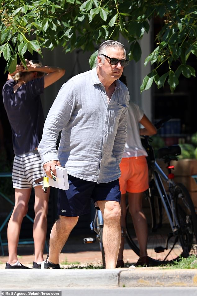 Alec Baldwin cuts a casual figure in navy blue shorts for a business ...