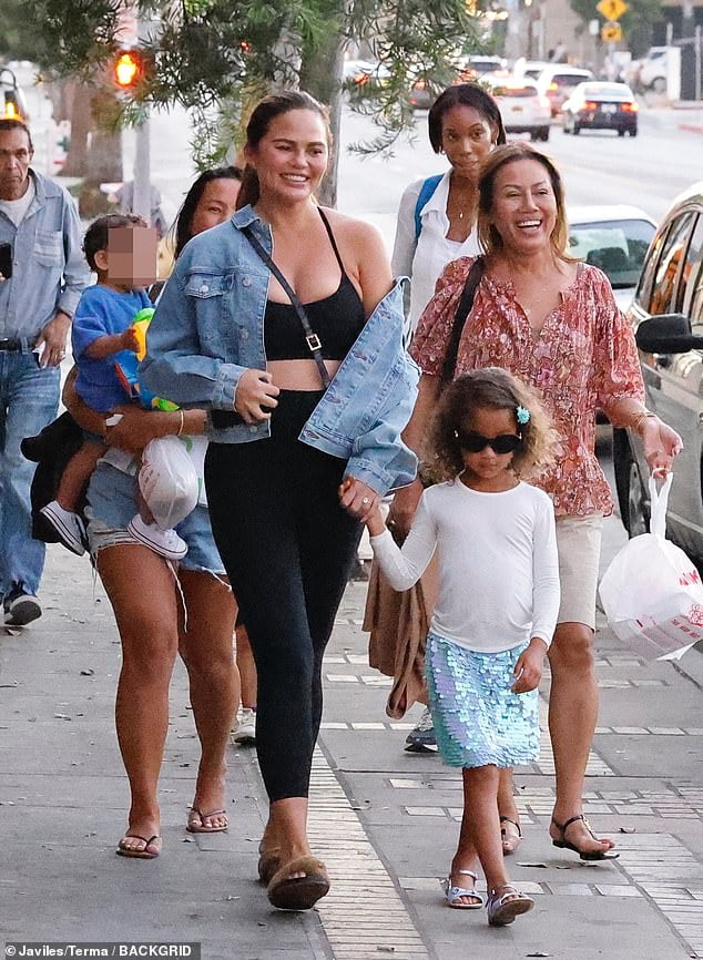 Chrissy Teigen flashes a wide smile while stepping out with her mother