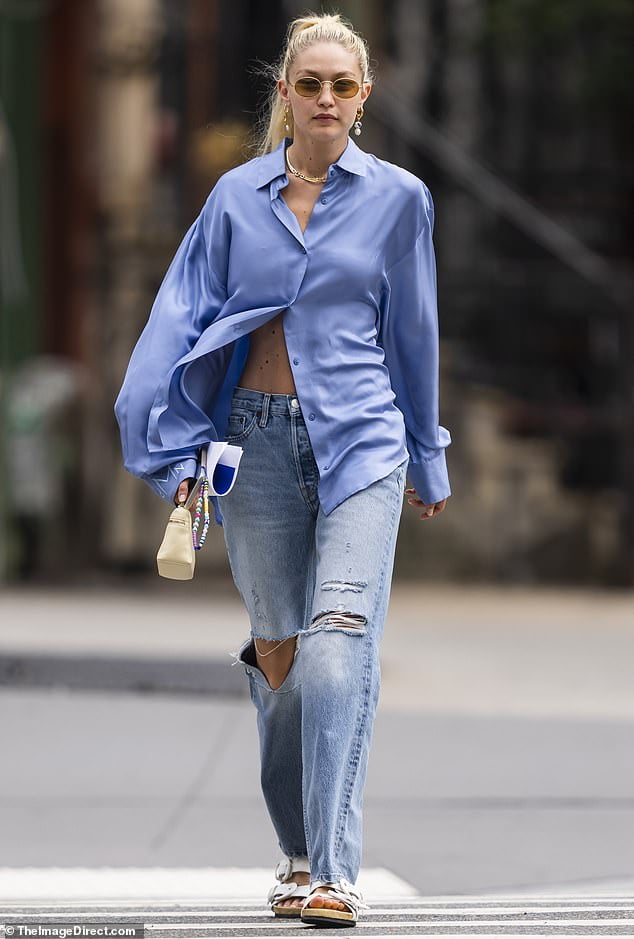 Gigi Hadid flashes her toned tummy in a barely buttoned blue men's ...