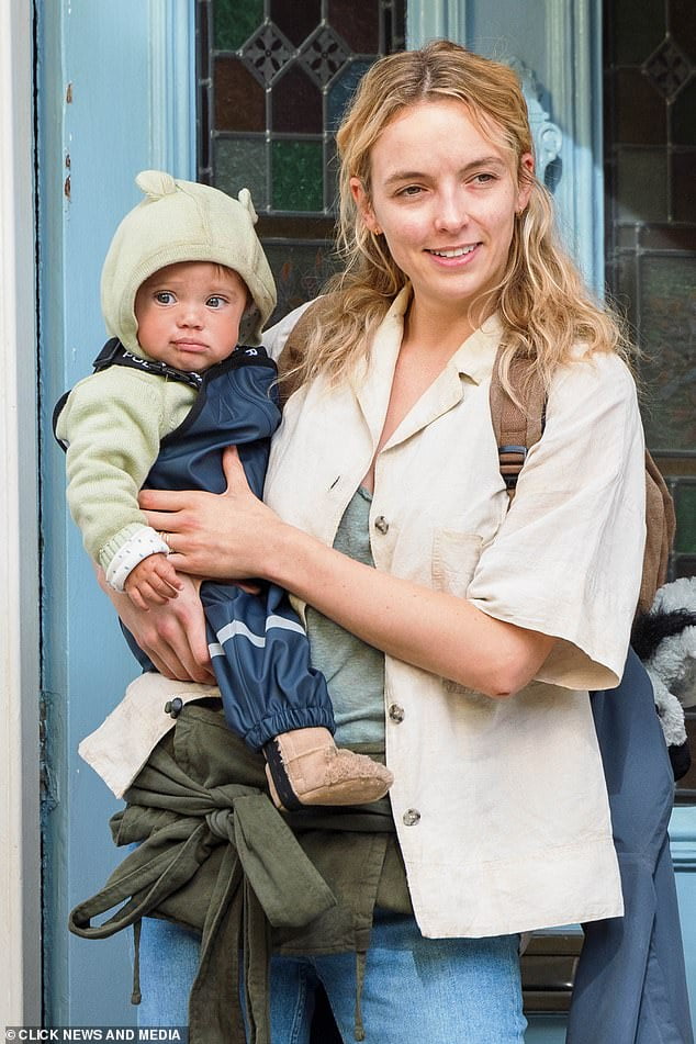 Dishevelled Jodie Comer comforts a baby while filming new dystopian ...