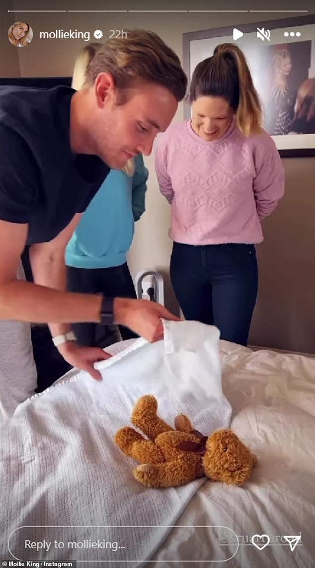 Mollie King's fiancé Stuart Broad practices swaddling a baby using a