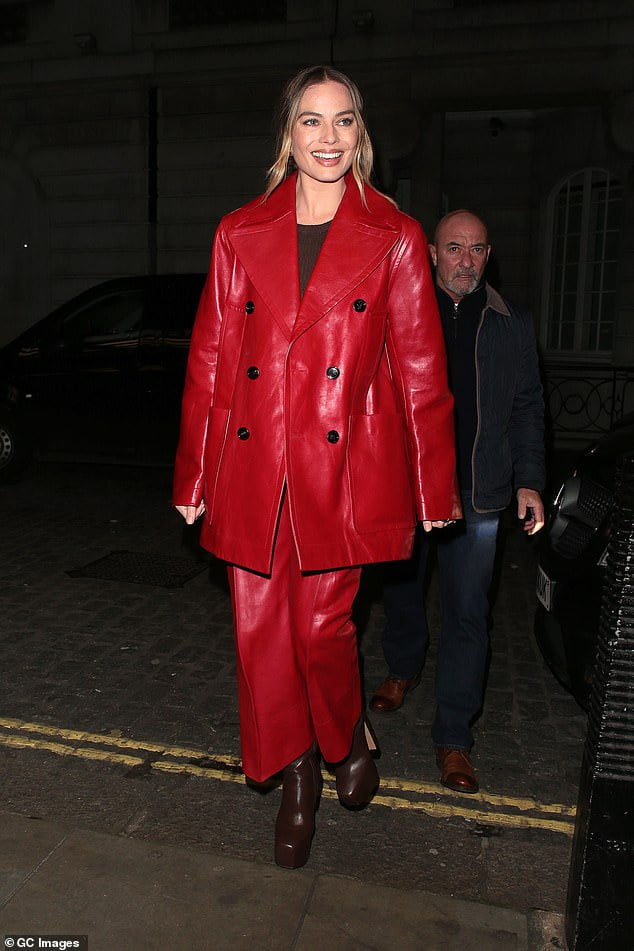 Margot Robbie slips into a stylish red leather coat as she attends the