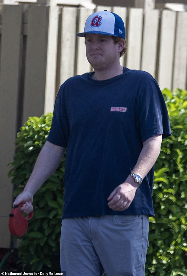 Buster Murdaugh looks strained as he breaks cover to walk his dogs with longtime girlfriend