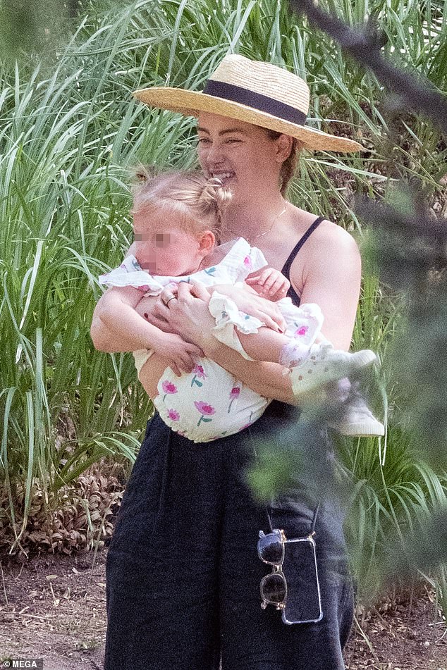 Amber Heard is pictured with her daughter in Madrid as Johnny Depp ...