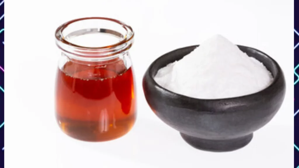 A bowl of sugar next to a jar of honey on a plain background 